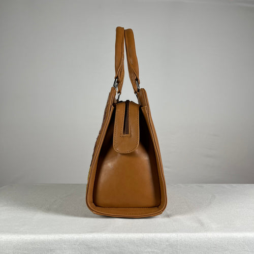 Close-up of hand embroidery on brown buffalo leather sling bag
