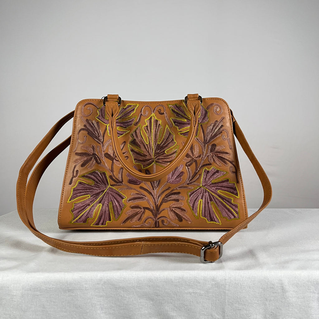 Inside view of brown buffalo leather sling bag showing zip pockets