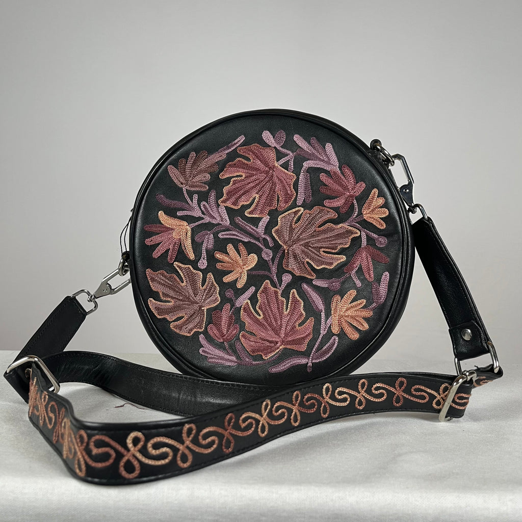 Close-up of hand embroidery on black leather circle bag